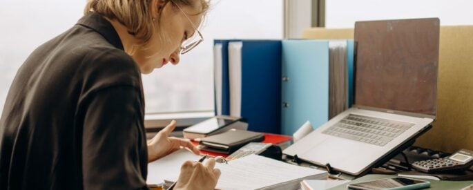 Photo by Mikhail Nilov: https://www.pexels.com/photo/woman-holding-a-pen-reading-notes-in-a-book-binder-8297033/